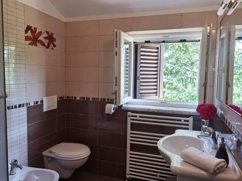 baño con aseo y lavabo y ventana en Apartment Luce, en Pićan