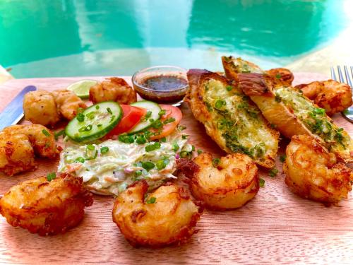 a plate of food with shrimp and vegetables on a table at Seconds Hostel - Colombo in Colombo