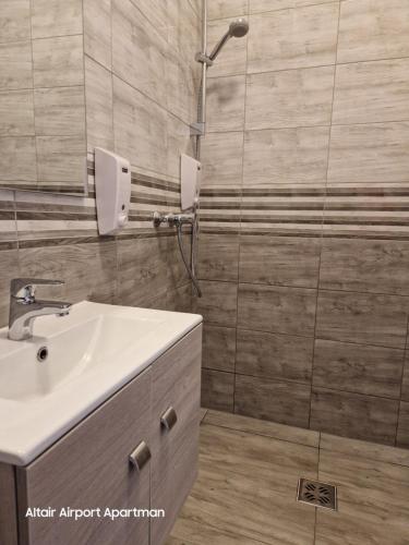 a bathroom with a sink and a shower at Altair Airport Apartman in Vecsés
