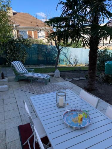 - une table de pique-nique blanche avec une assiette de nourriture dans l'établissement La maison parisienne & jardin, à Argenteuil