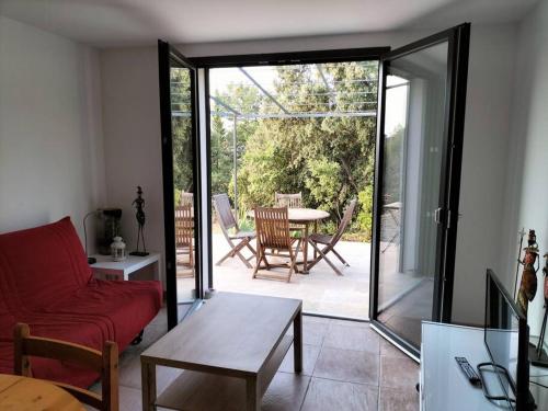 a living room with a red couch and a table at Logement, Quartier calme, Haut Var in Sillans-la Cascade