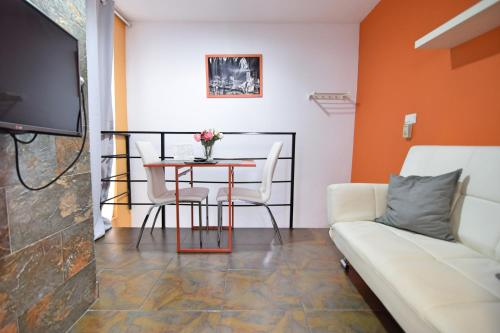 a living room with a table and a couch at Apartamentos Marques De La Merced in Málaga