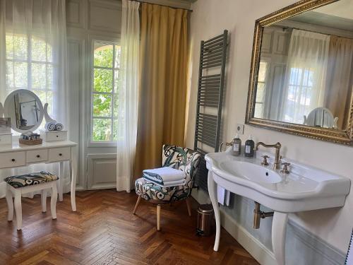 a bathroom with a sink and a mirror and a chair at VILLA CHIOVENDA Residenza d'Epoca in Premosello Chiovenda