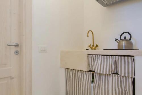 a kitchen counter with a sink and a kettle on it at Masseria Trulli sull'Aia in Cisternino