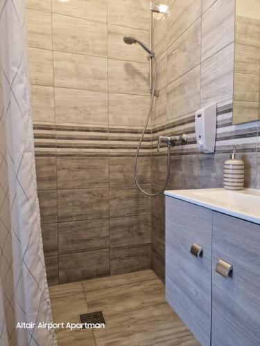 W łazience znajduje się prysznic i umywalka. w obiekcie Altair Airport Apartman w mieście Vecsés
