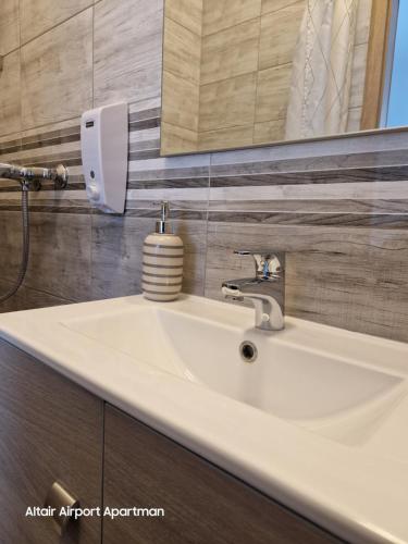 a white sink in a bathroom with a mirror at Altair Airport Apartman in Vecsés