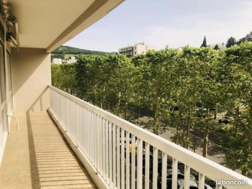 Elle comprend un balcon avec une balustrade blanche et des arbres. dans l'établissement BLUE IRO - lumineux - spacieux 105m² - balcon, à Saint-Étienne