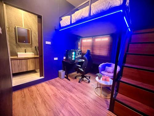 Arena eSports Hotel @ Bugis Village في سنغافورة: غرفة نوم مع سرير بطابقين مع مكتب وكمبيوتر