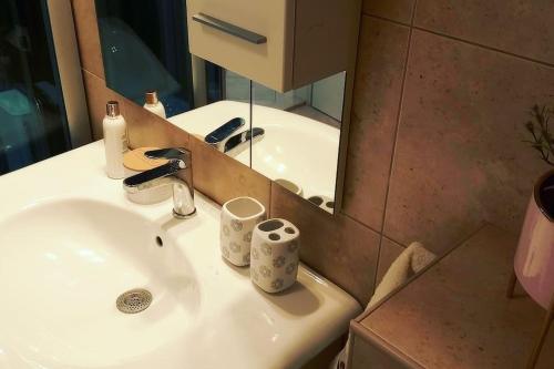 La salle de bains est pourvue d'un lavabo et d'un miroir. dans l'établissement Apartment Pupila, à Solin