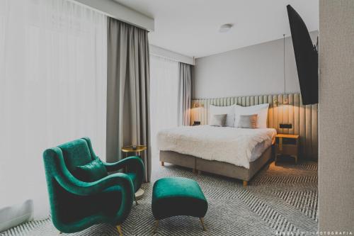 a hotel room with a bed and a chair at Royal Tulip Warsaw Centre in Warsaw