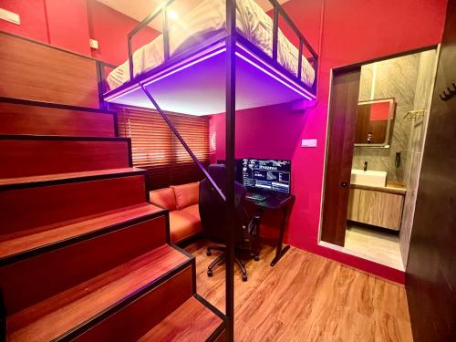 a room with a loft bed with a desk and a computer at Arena eSports Hotel @ Bugis Village in Singapore