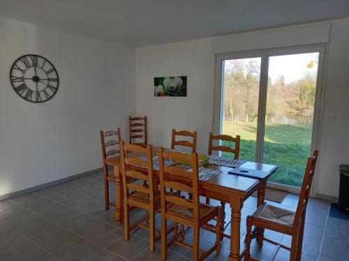 les granges de Soulagnieux et sa piscine privée في Piégut-Pluviers: غرفة طعام مع طاولة وكراسي خشبية