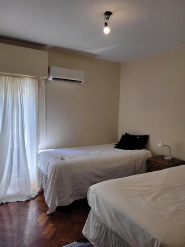 Habitación de hotel con 2 camas y ventana en Peatonal Sarmiento Mendoza departamento en Mendoza