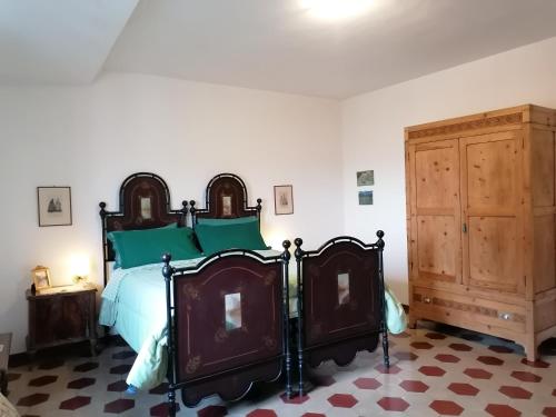 een slaapkamer met een bed en een houten kast bij Residenza Le Ortensie in Todi