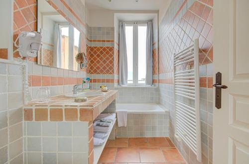 uma casa de banho com uma banheira, um lavatório e uma banheira tubermott em Omma em Roussillon
