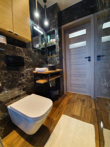 bagno con servizi igienici bianchi e lavandino di Galaxy Apartments a Słupsk