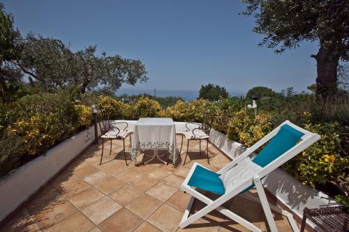 a patio with chairs and a table and a table and chairs at Il Giardino dell'Arte in Anacapri