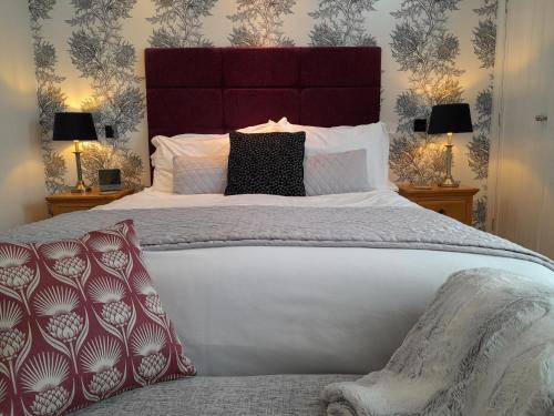 a bedroom with a large bed with red and white pillows at The Briarfields in Torquay
