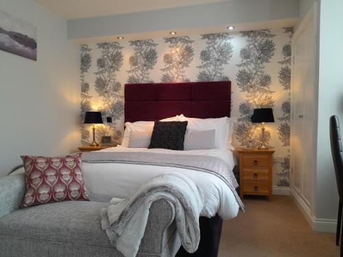 a bedroom with a large bed with a red headboard at The Briarfields in Torquay