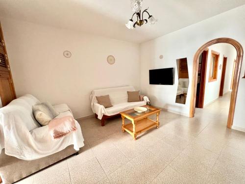Casa Los Jameos في بونتا موخيريس: غرفة معيشة مع أريكة وطاولة
