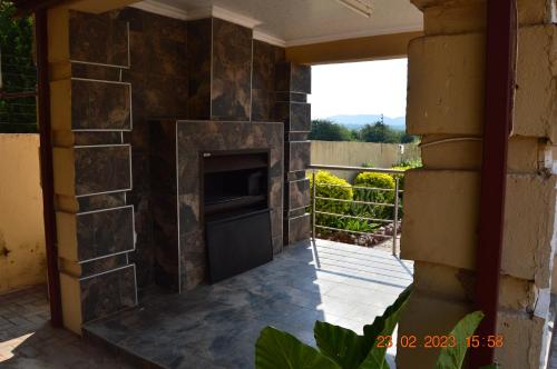 a stone fireplace in the side of a house at Glorious Home Bed & Breakfast in Mochudi