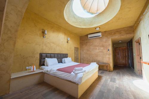 a bedroom with a large bed with a round ceiling at Bait Ali in Wadi Rum