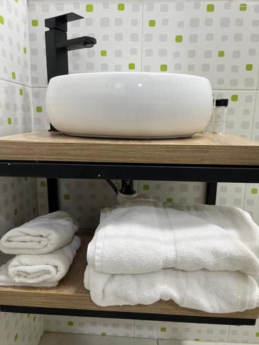 a bathroom with a sink and towels on a shelf at HOTEL 9.5 SAN FERNANDO in Cali