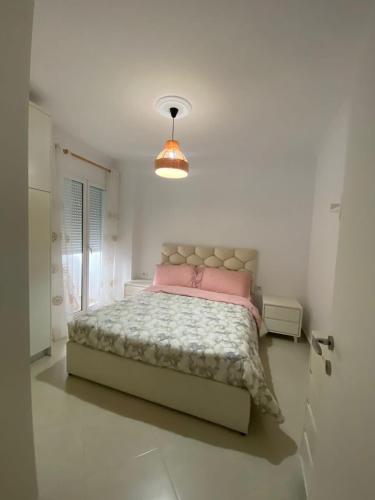 1 dormitorio con 1 cama en una habitación blanca en Lungo mare holiday apartment for family en Vlorë