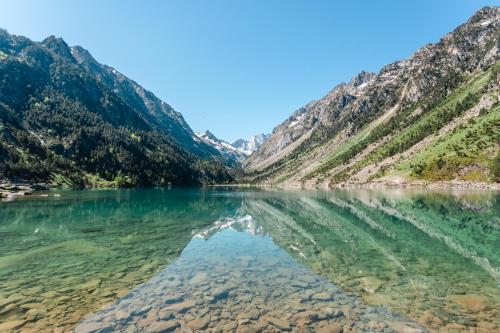 a lake in the mountains with its reflection in the water at Charmant T2, parking privé in Argelès-Gazost