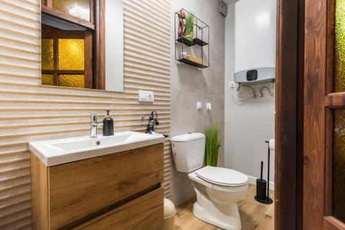 a bathroom with a toilet and a sink and a mirror at Apartament gościnny in Niepołomice