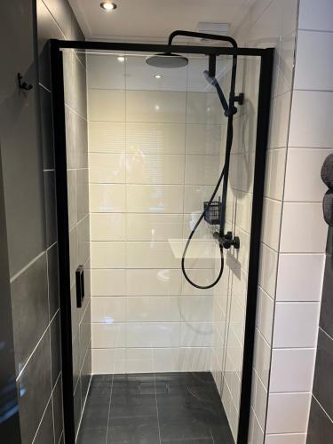 a shower with a glass door in a bathroom at B&B 'Op Eemdijk' in Eemdijk