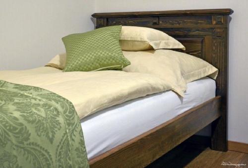 Una cama con cuatro almohadas encima. en Vincze Vendeghaz, en Kiskunhalas