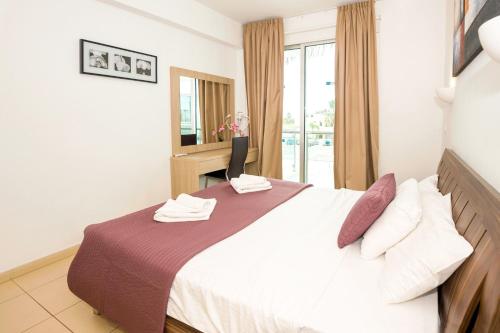 ein Schlafzimmer mit einem großen Bett und einem Fenster in der Unterkunft BLISS - Beachfront Apartment in Protaras