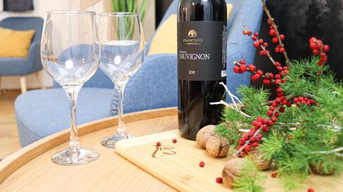 - une bouteille de vin et 2 verres à vin sur une table dans l'établissement Villa Blue Apartman, à Szekszárd