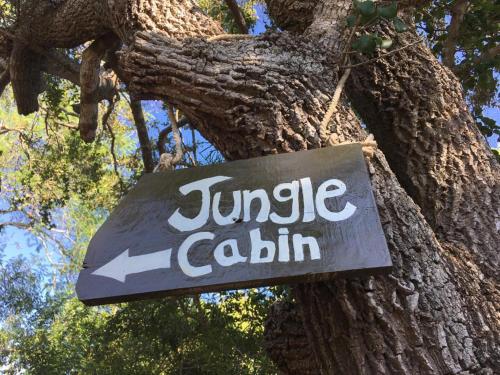 a sign is hanging from a tree at Jungle Cabin in Bundala Levagamgoda