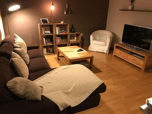 ein Wohnzimmer mit einem Sofa und einem TV in der Unterkunft MODERNO APARTAMENTO EN EL CENTRO in Vilanova i la Geltrú