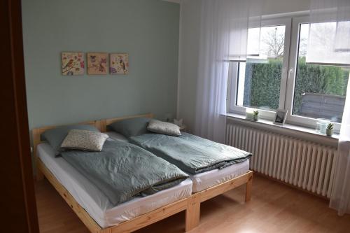 a bedroom with a bed in a room with two windows at FeWo am Naturschutzgebiet in Hiddenhausen