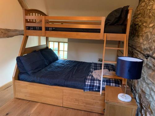 a bedroom with a bunk bed with a blue bed at Yr Hen Efail in Llanfihangel-yng-Ngwynfa