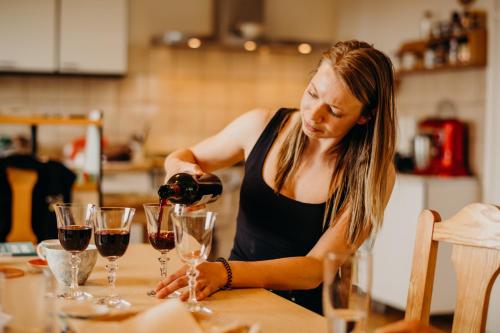 a woman pouring wine into wine glasses on a table at Grunt Sonek in Mislinja