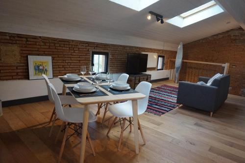 une salle à manger avec une table et des chaises blanches dans l'établissement Un Air de Campagne - Gîtes 4 étoiles, à Beauzelle
