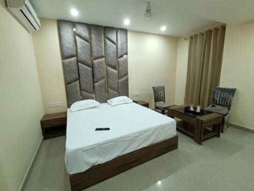 a bedroom with a bed and a table and chairs at The Cape Grace Hotel in Jalandhar