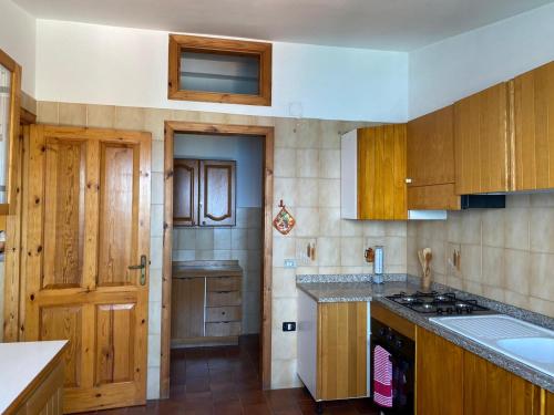 - une cuisine avec des placards en bois et un comptoir dans l'établissement La Casa di Giorgio, à Marina di Camerota