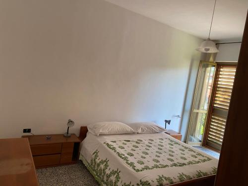 a bedroom with a bed and a dresser and a window at La Casa di Giorgio in Marina di Camerota