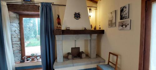 a living room with a fireplace and a window at Agriturismo La Scarpaia in Anghiari