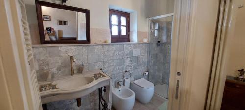 a bathroom with a sink and a toilet and a mirror at Agriturismo La Scarpaia in Anghiari