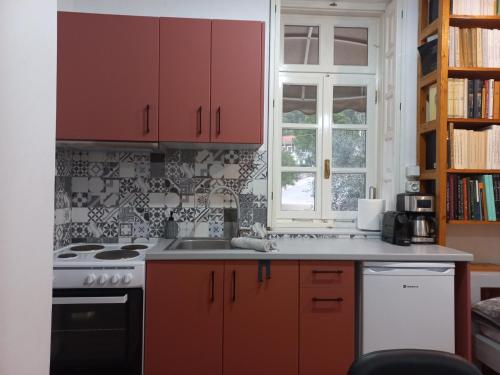 a kitchen with red cabinets and a stove at The Valkyries 2 in Leonidion