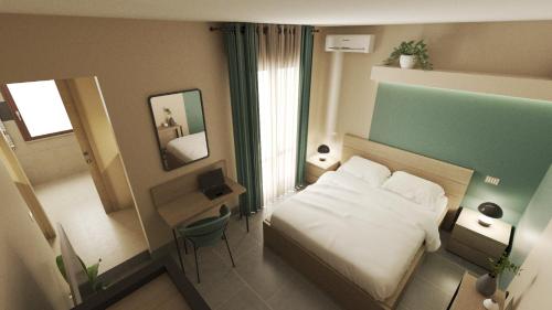 ein kleines Hotelzimmer mit einem Bett und einem Spiegel in der Unterkunft MONACO WAVES in Su Forti