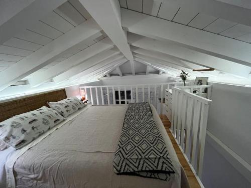 a bedroom with a white bed in a attic at Casa de invitados, a pie de playa, en La Torre Verde in El Puerto de Santa María