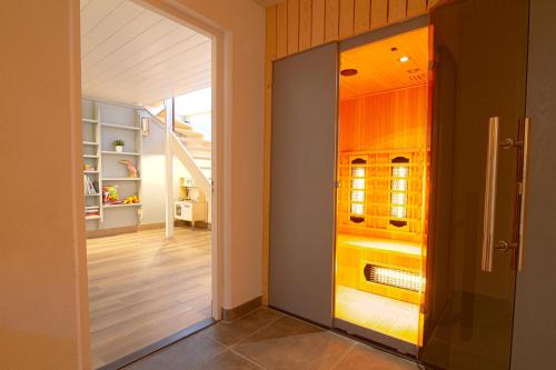 a hallway with an open door to a kitchen at Jacuzzi & Sauna Villa 2 in Tzummarum
