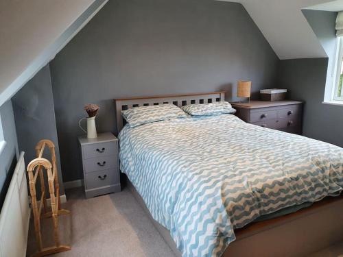 a bedroom with a large bed and a window at Countryside 3 Bed Detached Cottage in Royal Wootton Bassett